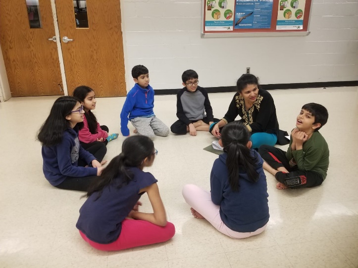 A group of people sitting on the floor Description automatically generated with medium confidence